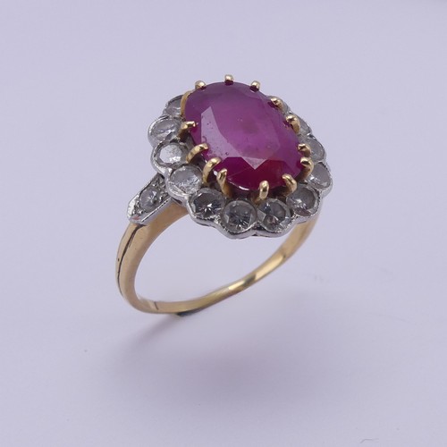 202 - A ruby and diamond cluster Ring, the central oval ruby approx. 11.4mm long, claw set above a surroun... 