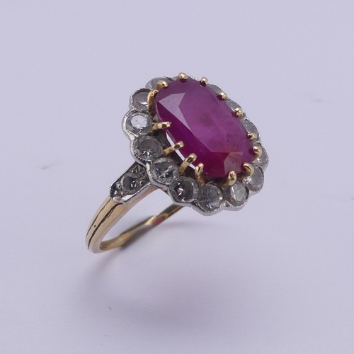 202 - A ruby and diamond cluster Ring, the central oval ruby approx. 11.4mm long, claw set above a surroun... 