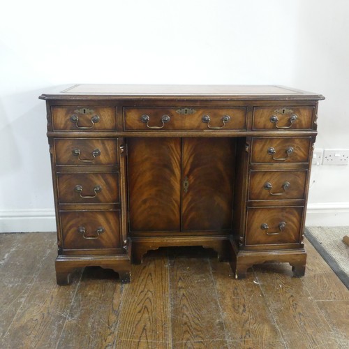 345 - A mahogany kneehole Desk, chamfered top inset with leather writing surface, above frieze drawer and ... 