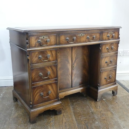 345 - A mahogany kneehole Desk, chamfered top inset with leather writing surface, above frieze drawer and ... 