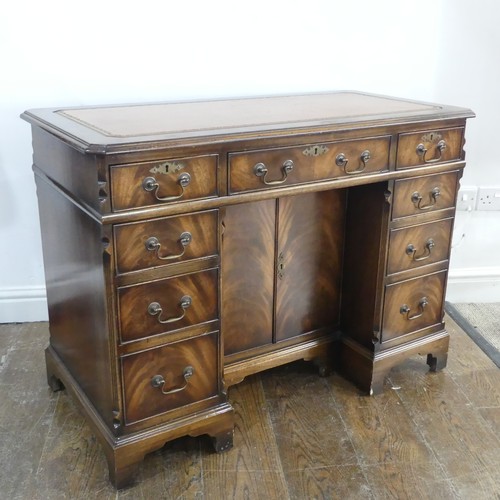 345 - A mahogany kneehole Desk, chamfered top inset with leather writing surface, above frieze drawer and ... 