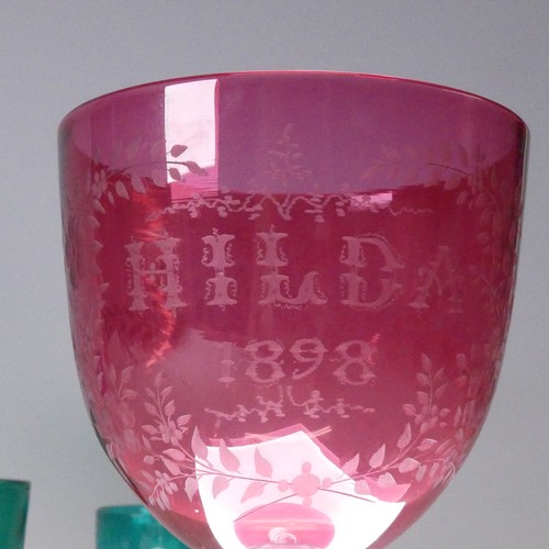 11 - A large Victorian engraved cranberry Glass, reading 'HILDA 1898' within foliate border, raised on ho... 