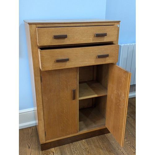 348 - A 1930s oak Tall Boy in the manner of Heals, two drawers over cupboard, all inset with Heals style o... 