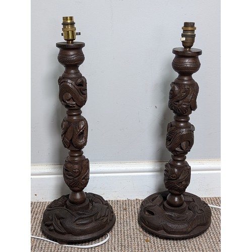 376 - A pair of Chinese carved hardwood table Lamps, columns decorated with spiraling dragons, H 54 cm.... 