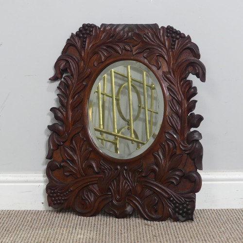 392 - An Arts and crafts carved oak wall Mirror, border with carved stylised flowers, note with some small... 