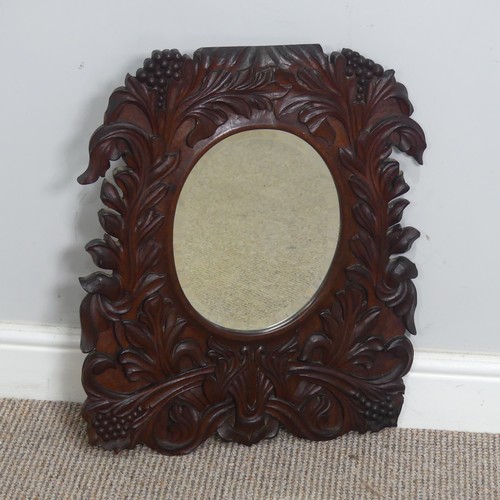 392 - An Arts and crafts carved oak wall Mirror, border with carved stylised flowers, note with some small... 