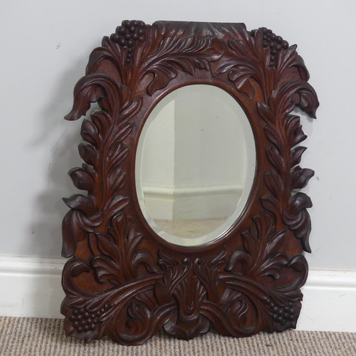 392 - An Arts and crafts carved oak wall Mirror, border with carved stylised flowers, note with some small... 