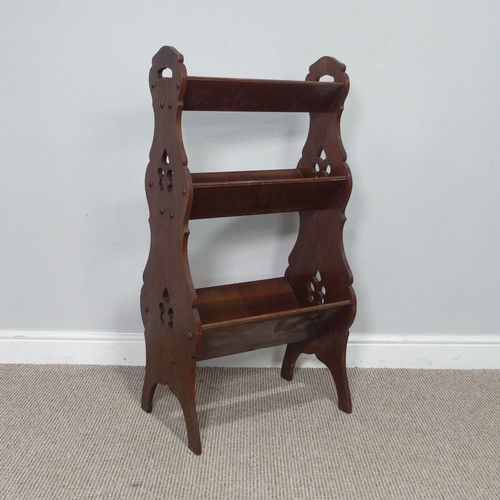 369 - An Arts and Crafts three tiered Book Trough / Magazine Rack, with pierced carrying handles and decor... 