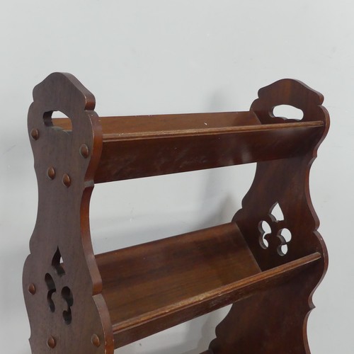 369 - An Arts and Crafts three tiered Book Trough / Magazine Rack, with pierced carrying handles and decor... 