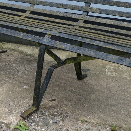 412 - A Victorian strapped iron Garden Bench / Seat, painted black, with scrolled supports and armrests, r... 