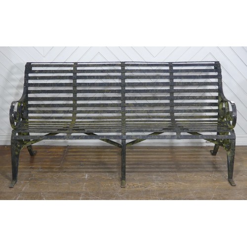 412 - A Victorian strapped iron Garden Bench / Seat, painted black, with scrolled supports and armrests, r... 