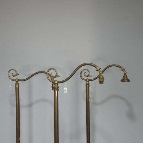 417 - A set of three Victorian brass standard Lamps, having a scrolled single sconce over a central cylind... 