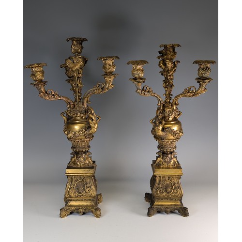 443 - A Pair of gilt metal four-branch Candelabra, in Louis XV style, with leaf-sheathed sockets and scrol... 