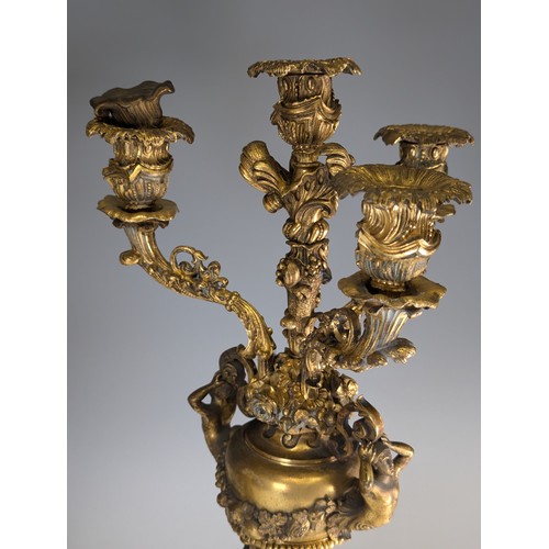 443 - A Pair of gilt metal four-branch Candelabra, in Louis XV style, with leaf-sheathed sockets and scrol... 