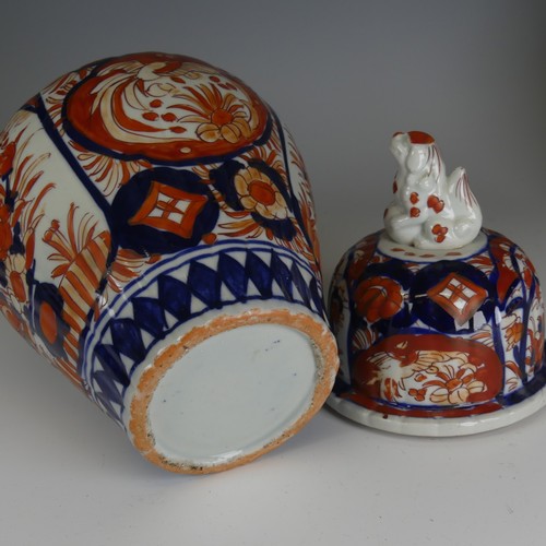 142 - A pair of Japanese imari Temple Jars, decorated in typical style with dog finial to cover, H 34cm, a... 