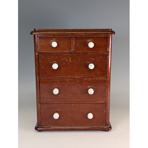 445 - An antique mahogany miniature / apprentice piece Chest of drawers, with ceramic handles, raised on b... 