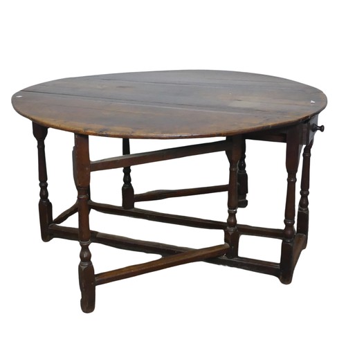 464 - An 18th century oak gateleg Table, with deep drawers to either end and raised on turned supports, W ... 