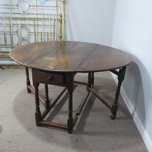 464 - An 18th century oak gateleg Table, with deep drawers to either end and raised on turned supports, W ... 