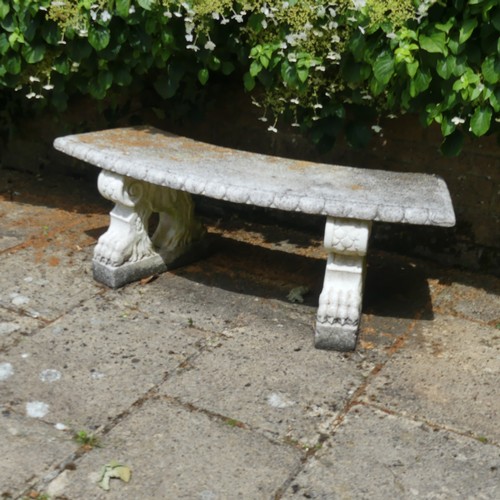 488 - A reconstituted stone garden Seat, of curved form raised on plinths, note split to underside, which ... 