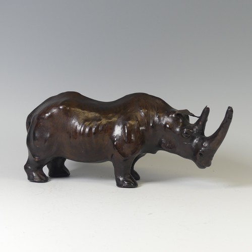 506 - In the manner of Liberty a leather model of a Rhino, with glass eyes, W 33 cm x H 14 cm x D 10 cm.... 