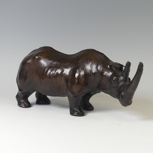 506 - In the manner of Liberty a leather model of a Rhino, with glass eyes, W 33 cm x H 14 cm x D 10 cm.... 