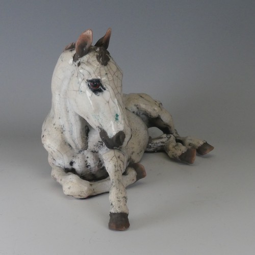 100 - Keza Rudge (British 20th century) a studio pottery Raku Horse, modelled in recumbent position with h... 