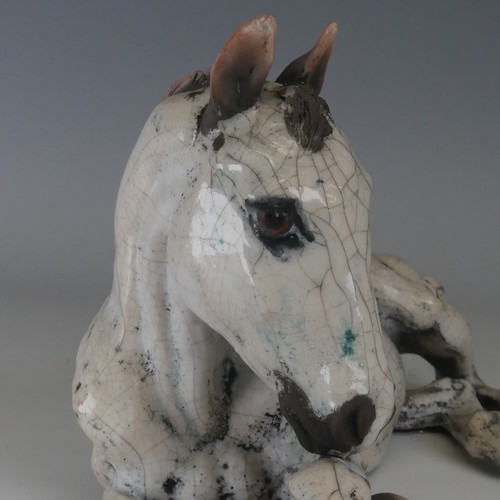 100 - Keza Rudge (British 20th century) a studio pottery Raku Horse, modelled in recumbent position with h... 