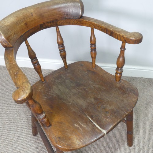 513 - An early 20th century ash and elms smokers bow Armchair, raised on turned supports, note, split to s... 