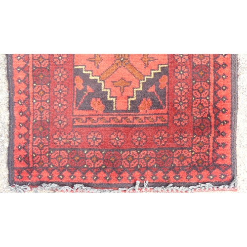 554 - Tribal Rugs: two small Afghan red-ground runners, both approx. 148cm x 52cm and in good condition (2... 