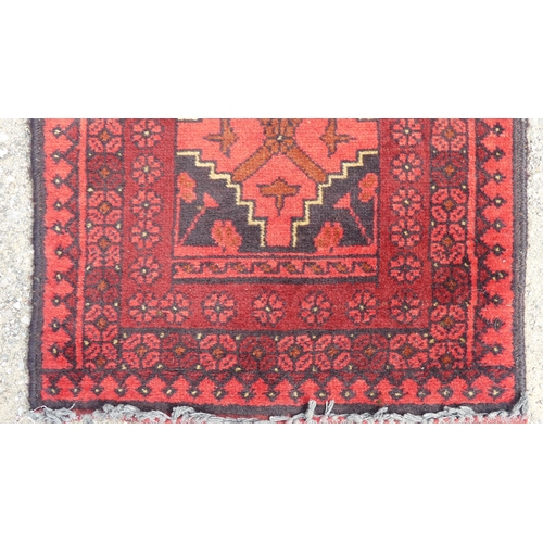 554 - Tribal Rugs: two small Afghan red-ground runners, both approx. 148cm x 52cm and in good condition (2... 