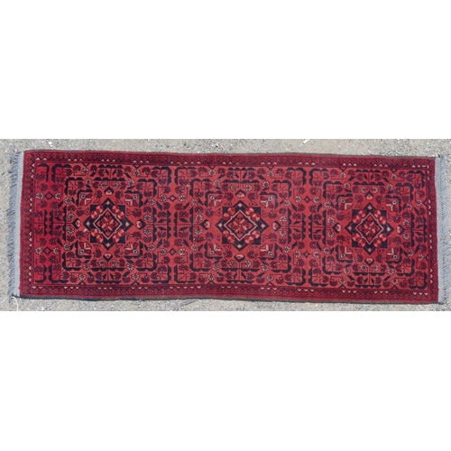 554 - Tribal Rugs: two small Afghan red-ground runners, both approx. 148cm x 52cm and in good condition (2... 