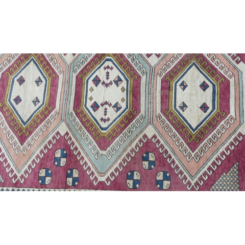 560 - Tribal Rugs; a hand-knotted Turkish pink and cream-ground Carpet, wool pile on wool base, 306cm x 23... 