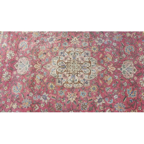 561 - Tribal rugs; a hand-knotted salmon-pink ground Persian carpet, wool pile on cotton base, with gold a... 