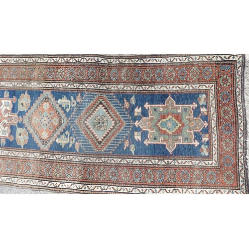 563 - Tribal rugs; a hand-knotted blue ground Caucasian Runner, wool pile on cotton and wool base, with da... 