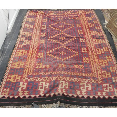 566 - Tribal rugs; a large red-ground Kelim, 100% wool flat weave, 330cm x 212cm, one edge damaged and one... 