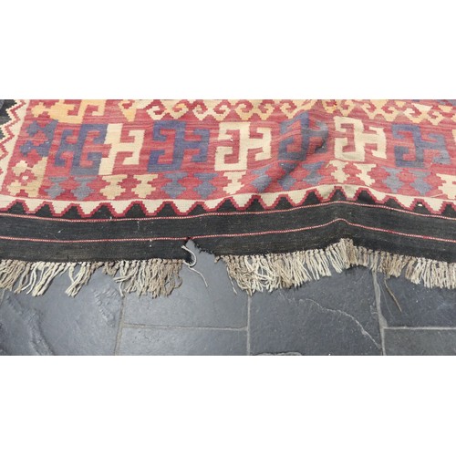 566 - Tribal rugs; a large red-ground Kelim, 100% wool flat weave, 330cm x 212cm, one edge damaged and one... 