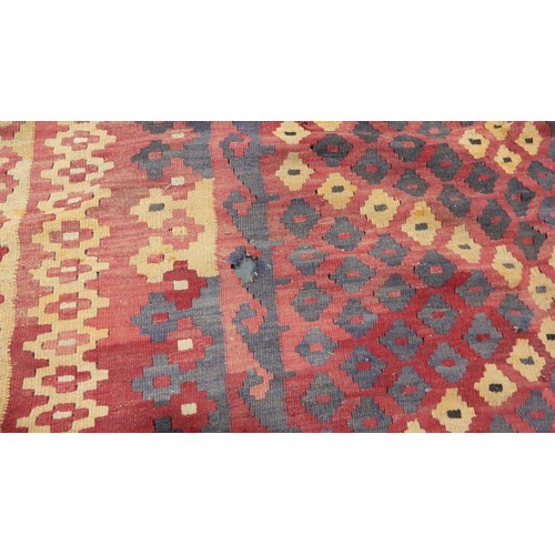 566 - Tribal rugs; a large red-ground Kelim, 100% wool flat weave, 330cm x 212cm, one edge damaged and one... 