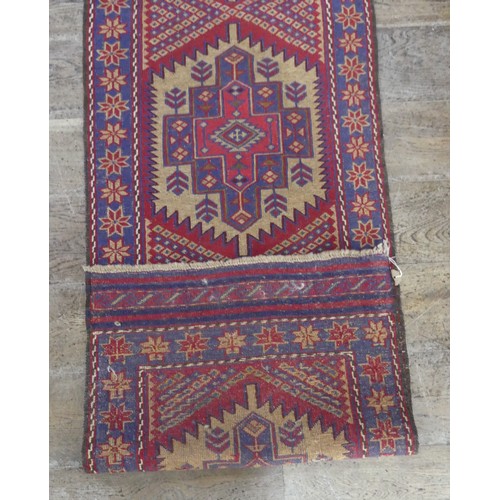 568 - Tribal Rugs; a Sumak Runner, red and blue ground, 100% wool, 288cm x 65cm.