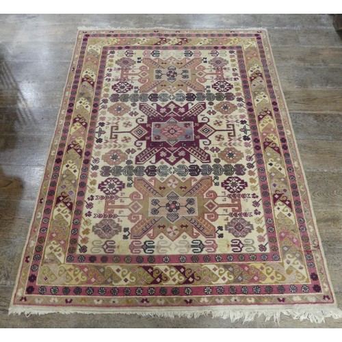 569 - Tribal Rugs; a Kazak rug, wool pile on cotton base, cream ground woven in traditional patterns in bu... 