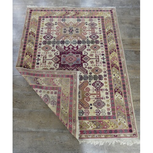 569 - Tribal Rugs; a Kazak rug, wool pile on cotton base, cream ground woven in traditional patterns in bu... 