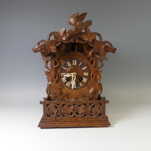 A late 19th Century Black Forest carved softwood mantel cuckoo