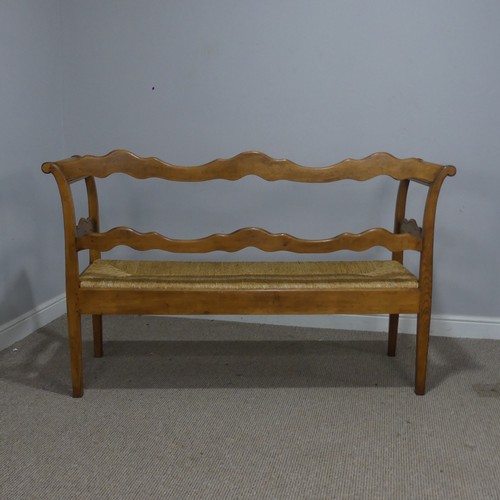 513 - A 20th century French oak and rush seat Bench/Sofa, with carved headrest and apron, flanked by scrol... 