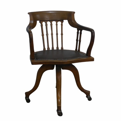 514 - An early 20th century Arts and Crafts style captains swivel desk Chair, shaped backrest and shaped s... 