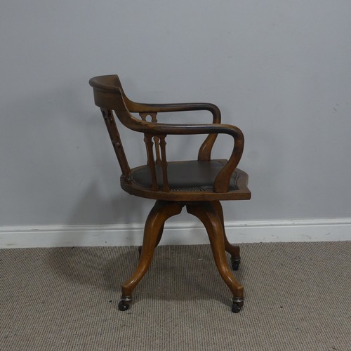 514 - An early 20th century Arts and Crafts style captains swivel desk Chair, shaped backrest and shaped s... 