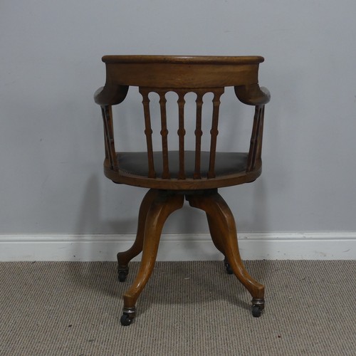 514 - An early 20th century Arts and Crafts style captains swivel desk Chair, shaped backrest and shaped s... 