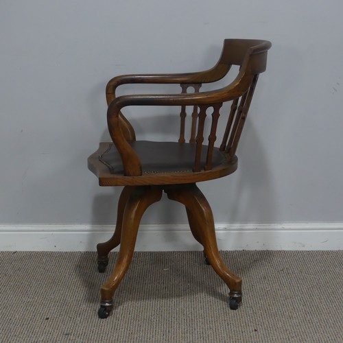 514 - An early 20th century Arts and Crafts style captains swivel desk Chair, shaped backrest and shaped s... 