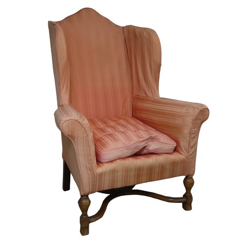 533 - An antique wingback Armchair in the Queen Anne style, domed high-back over scrolled armrests, raised... 