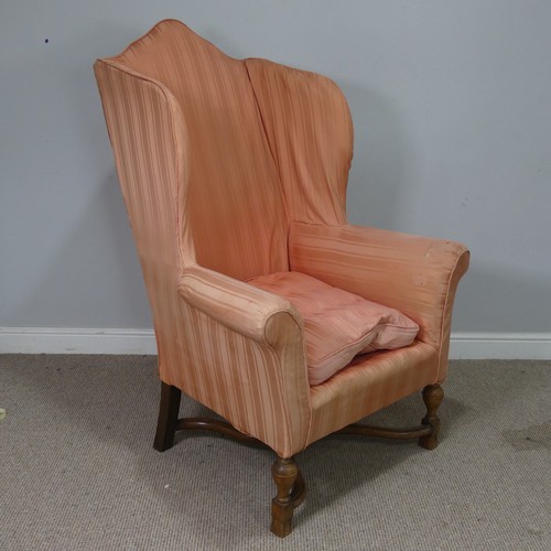 533 - An antique wingback Armchair in the Queen Anne style, domed high-back over scrolled armrests, raised... 