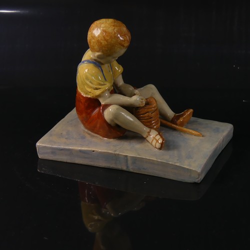 54 - Isobel Holland (1913-1986) a Clevedon Pottery figure of a Boy, modelled sat upright potting with a t... 