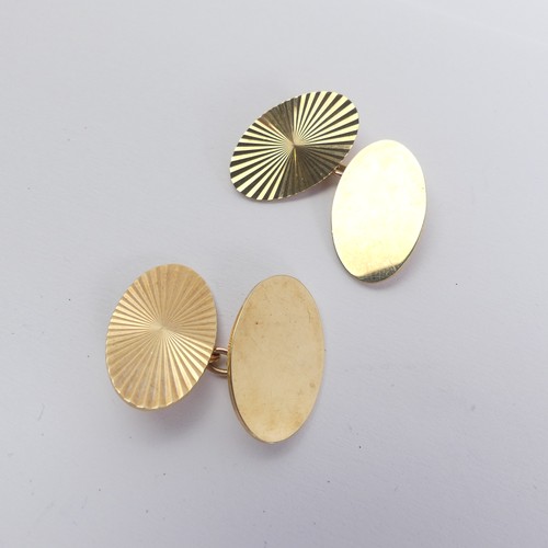 295 - A pair of 9ct yellow gold oval Cufflinks, the fronts with engraved starburst decoration, plain rever... 